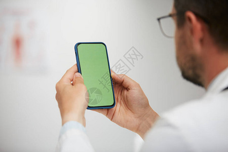 医生手持绿屏智能手机图片