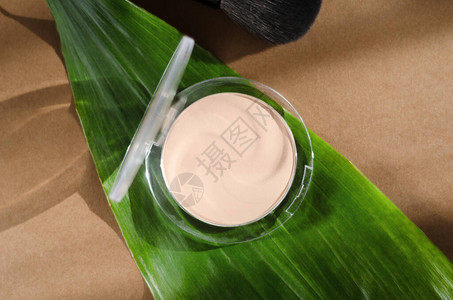 绿叶背景圆盒顶视图中的面粉时尚化妆品天然彩妆产品组成打开紧致粉底霜有机面部图片