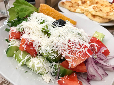 希腊沙拉是用西红柿片黄瓜片洋葱羊奶酪和橄榄制成的图片