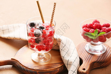 桌上放着冰块和冷冻浆果的玻璃杯图片