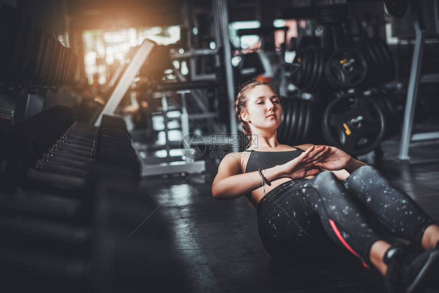 年轻有吸引力的健身女子在健身房里用机器和哑铃进行锻炼个人运动为健康的生活概念而使
