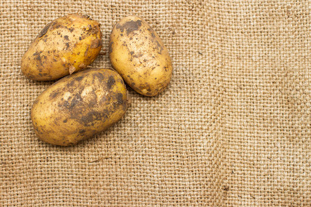 棕色袋子上带皮的新鲜土豆图片