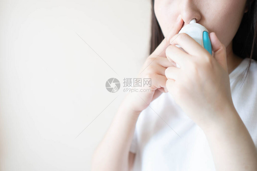 年轻女使用类固醇鼻喷雾悬浮液来缓解打喷嚏流鼻涕或鼻子发痒等症状用于治疗过敏鼻炎花粉热鼻窦炎或鼻息图片