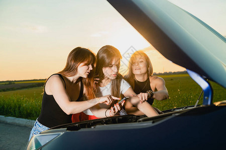 三个女孩在修理汽车发动图片