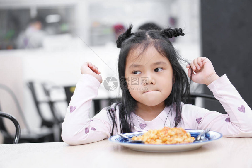 亚洲儿童可爱或小女孩厌食症或悲伤和无聊的食物或令人讨厌的无聊图片