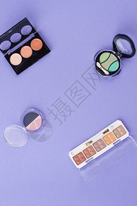 紫色背景上的各种化妆粉末图片