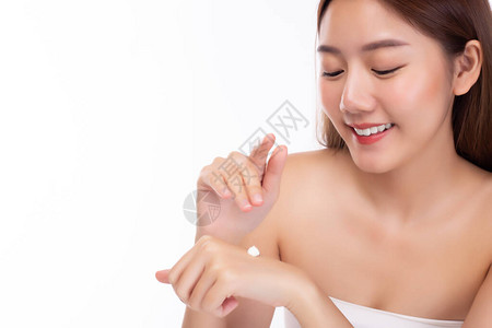 美丽的亚洲女人将身体乳液或防晒乳液涂抹在手上图片