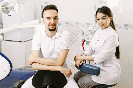一名男牙医和一名女助理准备在牙科图片