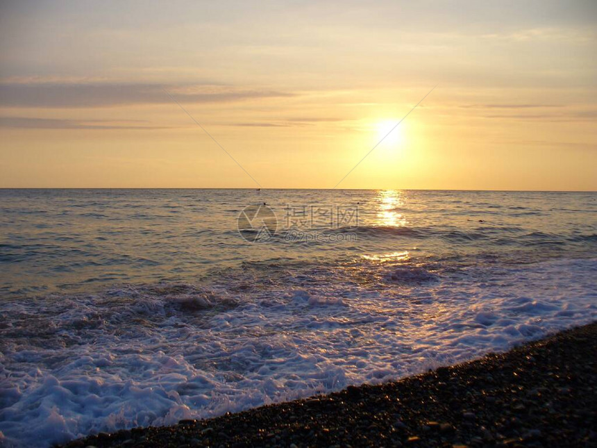 海上冲浪日落时分在海边冲浪海浪的美丽风景在日落的傍晚sunhore的背景下海浪以太阳为背图片