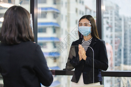 戴医用口罩和面罩的女可以防止空气传播疾病访客问候韦图片