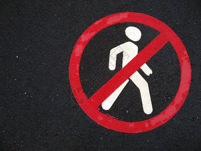禁止行人移动的柏油路标志行人不得步行雨后道路上交叉红色圆圈和人的标志图片