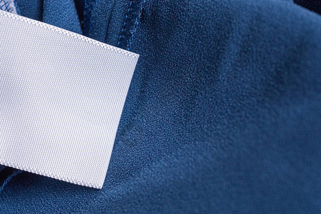 蓝色连衣裙上的洗衣护理服装标签图片