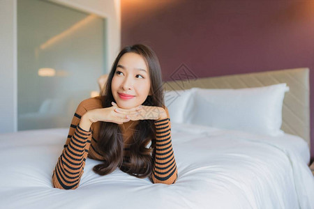 肖像美丽的亚洲年轻女微笑在卧室图片