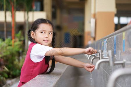 亚洲儿童可爱或小女孩和学生微笑着开心地在幼儿园学校或学前班的公共水槽中洗手背景图片