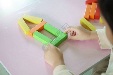 儿童或小女孩正在考虑玩彩色木块玩具图片