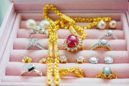 豪华珠宝盒中的金银钻石宝蓝宝石戒指项背景图片