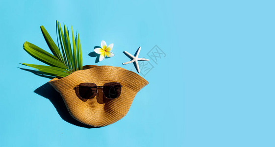 夏季帽子蓝色背景上戴太阳镜享受假日概图片