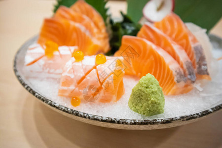 野生菜和新鲜的鲑鱼肉片沙西米以日本背景图片