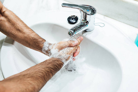 在浴室用肥皂洗手的人手图片