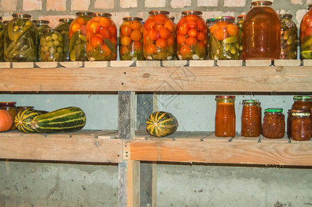 用于在地窖的架子上储存带有罐装蔬菜水果和浆果的食物的玻璃罐图片