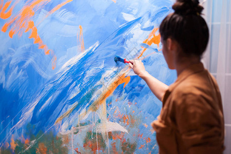 年轻女子在艺术工作室的大画布上画一幅杰作背景图片