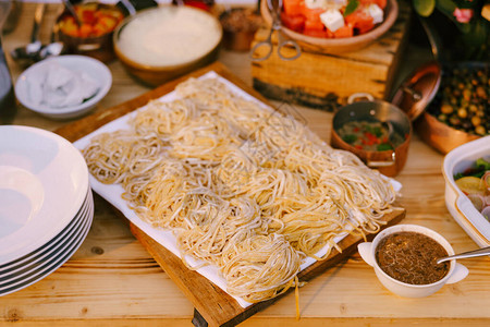 木制板上的意大利面条用煮熟的饭和干图片