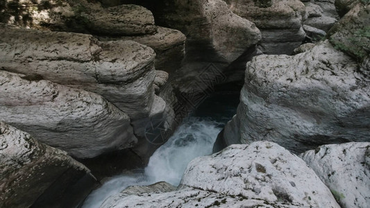 在狭小峡谷的岩石之间流淌着山地河水流图片
