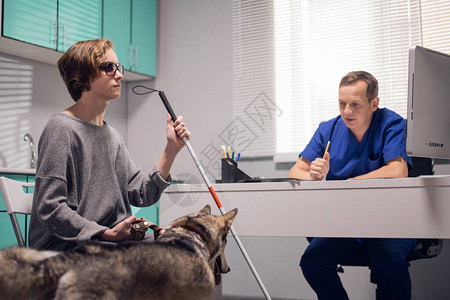 一位带着导盲犬在兽医诊图片