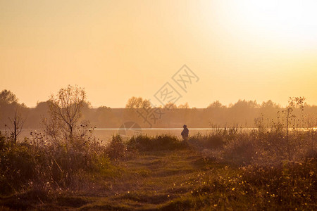夕阳下河边的渔夫图片