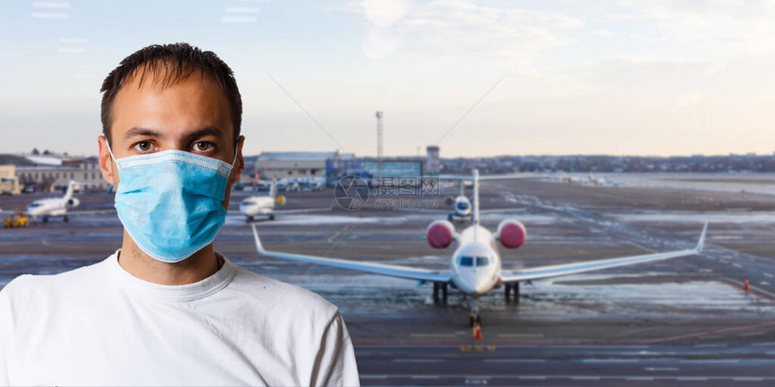 携带行李在国际机场休息室戴防面具的男子图片