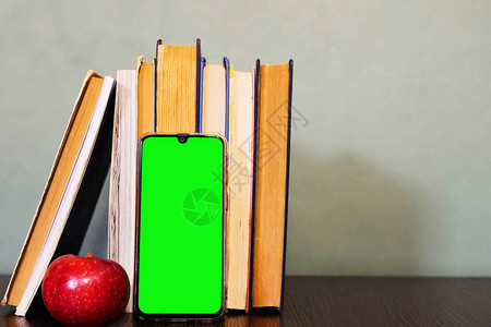 互联网图书馆一堆书和智能手机与绿屏教育理念阅读古典文学科学研究复制空背景图片