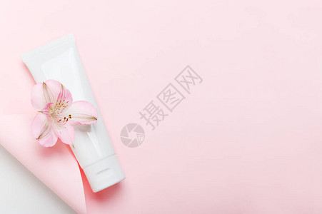 柔和的粉红色背景上的女卫生产品管洗发水护手霜牙膏白色包装侧视图在纸页上与滚动护肤品面霜保湿霜图片