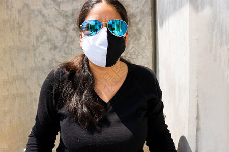 中年妇女戴白黑面罩和黑色面具穿黑色毛衣图片