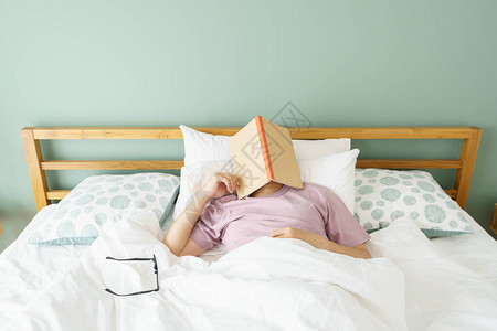 亚洲帅哥睡觉时看书人书嗜睡导致睡眠充足睡眠的概图片