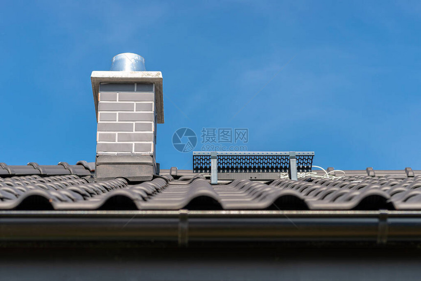 一栋独户住宅的屋顶覆盖着一块新的无烟煤瓷砖图片