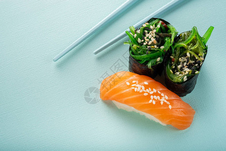 蓝色背景中带筷子的两道海藻寿司Chuka和图片