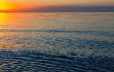 水面初凝海上太阳的黎明山后初升的太阳背景