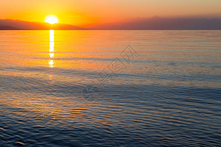 水面初凝海上太阳的黎明山后初升的太阳背景