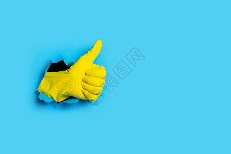 手戴黄色手套在浅蓝色背景的课图片