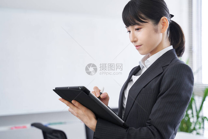 一名日本女商人在其办公室举行的图片