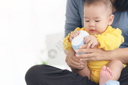 慈爱的妈在家里的沙发上给婴儿穿鞋图片