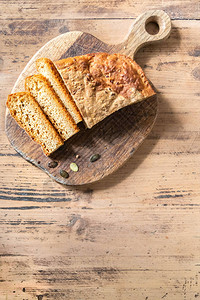 新鲜烤南瓜面包在生锈餐桌上的切板上图片