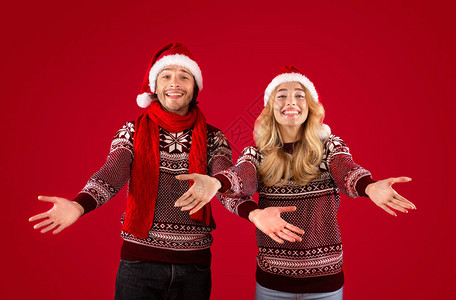 圣诞装扮的好情客小情侣在红背景上高清图片