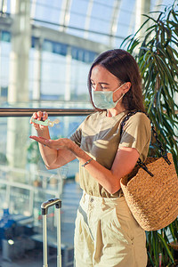 戴面罩的旅游女孩在国际机场预防用于和疾病防护的公背景图片