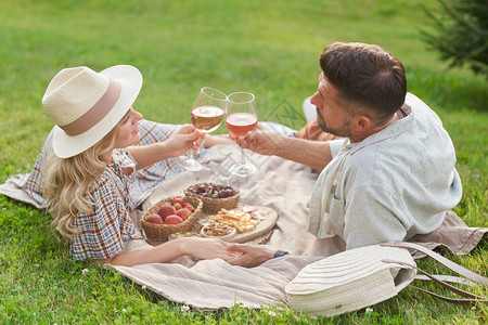 爱的成年情侣在阳光下野餐和浪漫约会室外露天时连着红酒图片