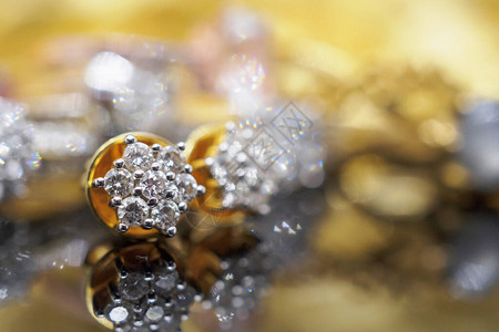 黑色背景反射的豪华黄金珠宝钻石耳环图片