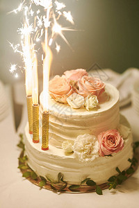 白结婚蛋糕在婚礼庆典的闭幕式上烧蜡烛图片