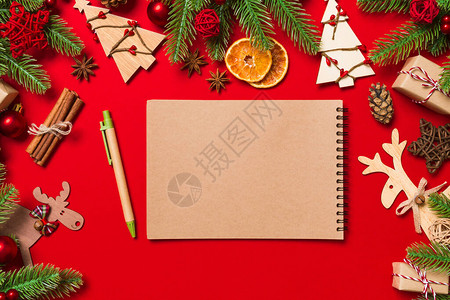 红色背景的顶级笔记本由圣诞装饰制图片