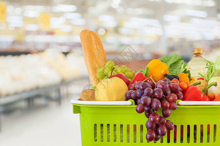 超市杂货店里装满水果和蔬菜的购物篮模糊了散景图片