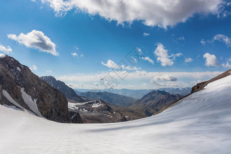 吉尔斯坦的山地景观山谷景观中的岩石雪和石头山全景吉尔斯坦阿拉图山脉图片